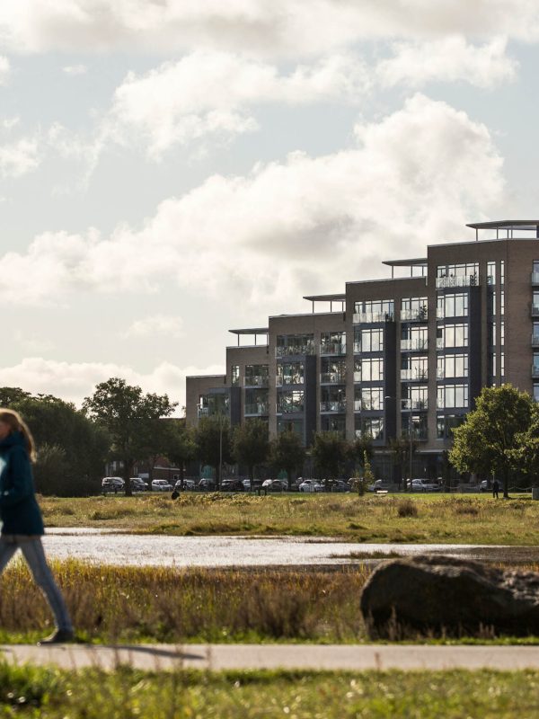 Person gÃ¥r tur i naturskÃ¸nt omrÃ¥de foran Strandkanten